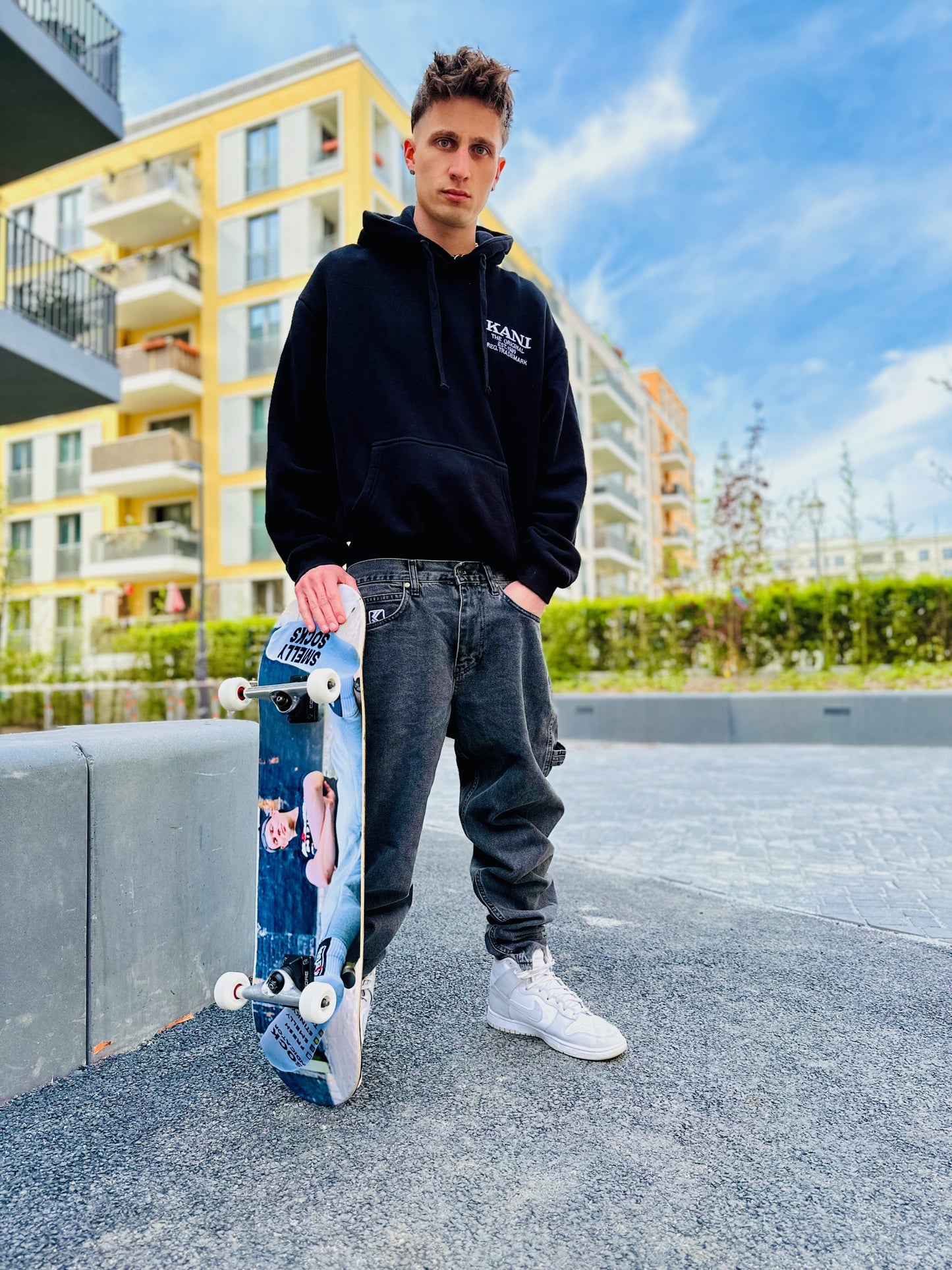 Junger gay skateboarder in Sk8erboy® Streetwear zeigt SNFF ME Socke – lässiger Mix aus Skate-Style und Gay Fetish Fashion.