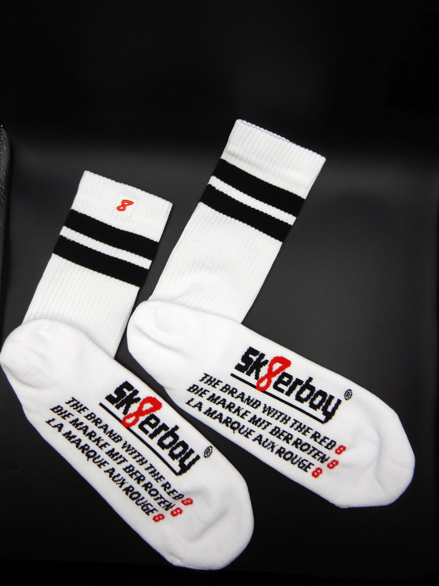 Weiße Sk8erboy® Retro Socken mit schwarzen Streifen und rotem 8er Logo. Sportsocken im 80er-Jahre Look, ideal für Fetish, Streetwear und Clubwear.