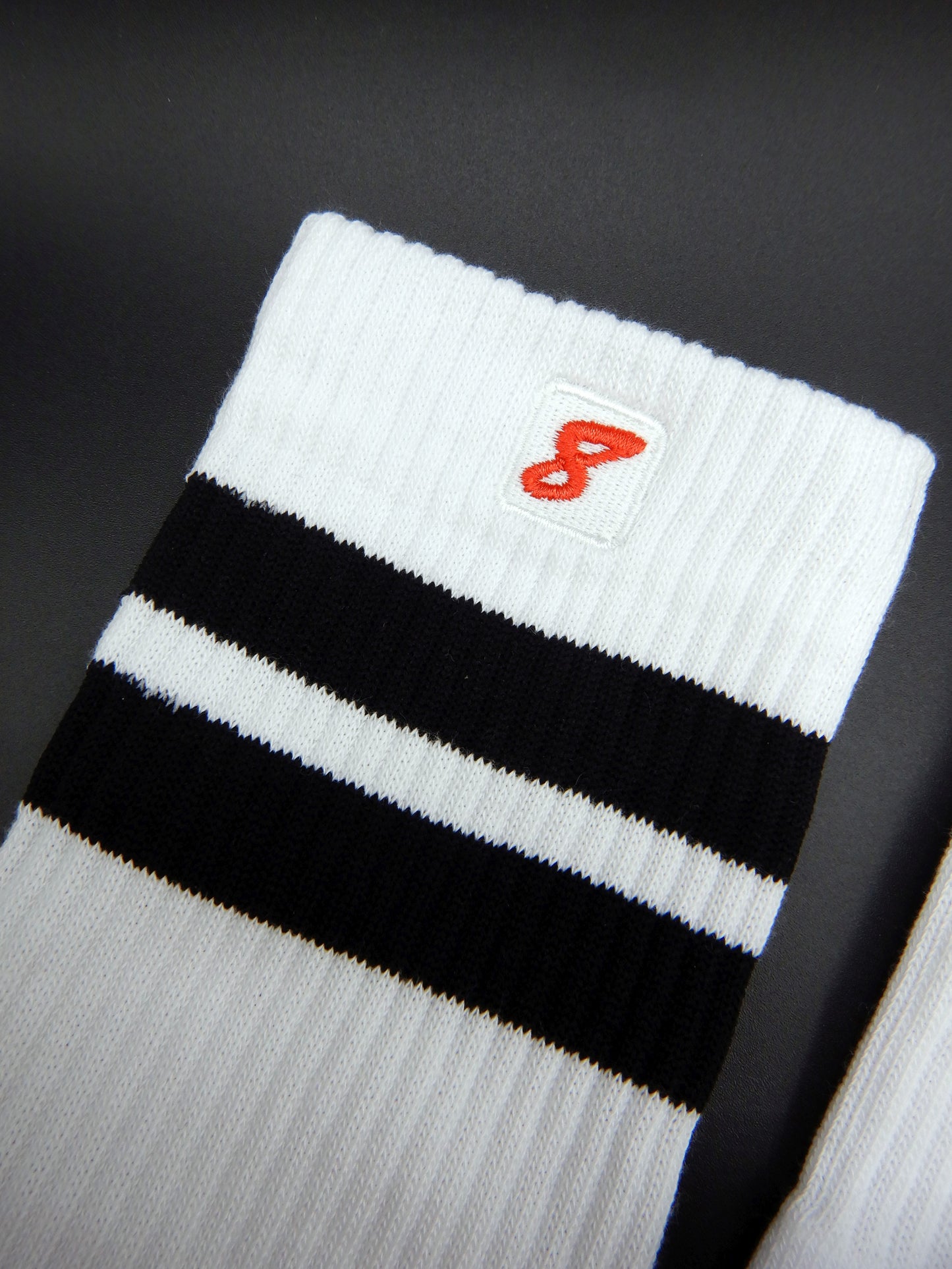 Weiße Sk8erboy® Retro Socken mit schwarzen Streifen und rotem 8er Logo. Sportsocken im 80er-Jahre Look, ideal für Fetish, Streetwear und Clubwear.