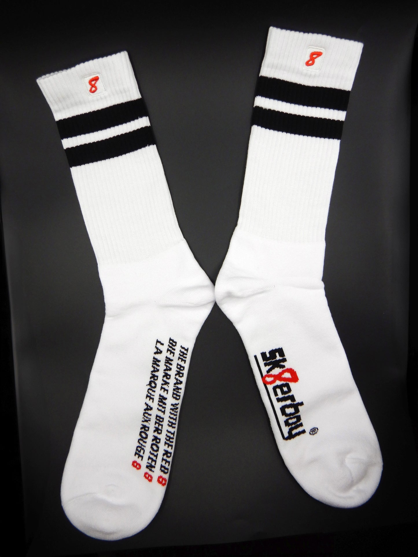 Weiße Sk8erboy® Retro Socken mit schwarzen Streifen und rotem 8er Logo. Sportsocken im 80er-Jahre Look, ideal für Fetish, Streetwear und Clubwear.