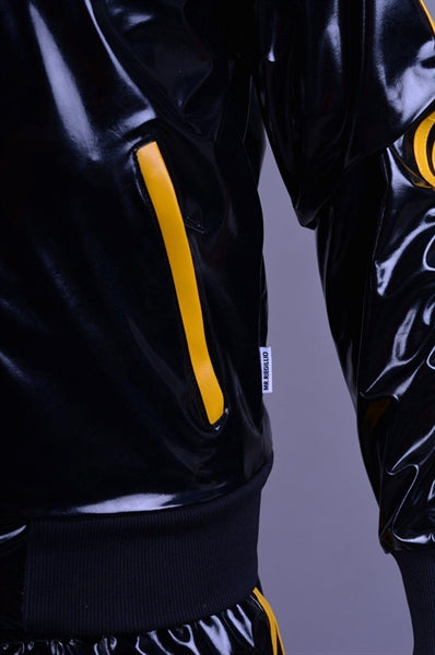 MR Riegillio PVC Tracksuit jacke mit gelben streifen von einem jungen gay getragen in schwarz glänzend von vorne eine nahaufnahme der taschen