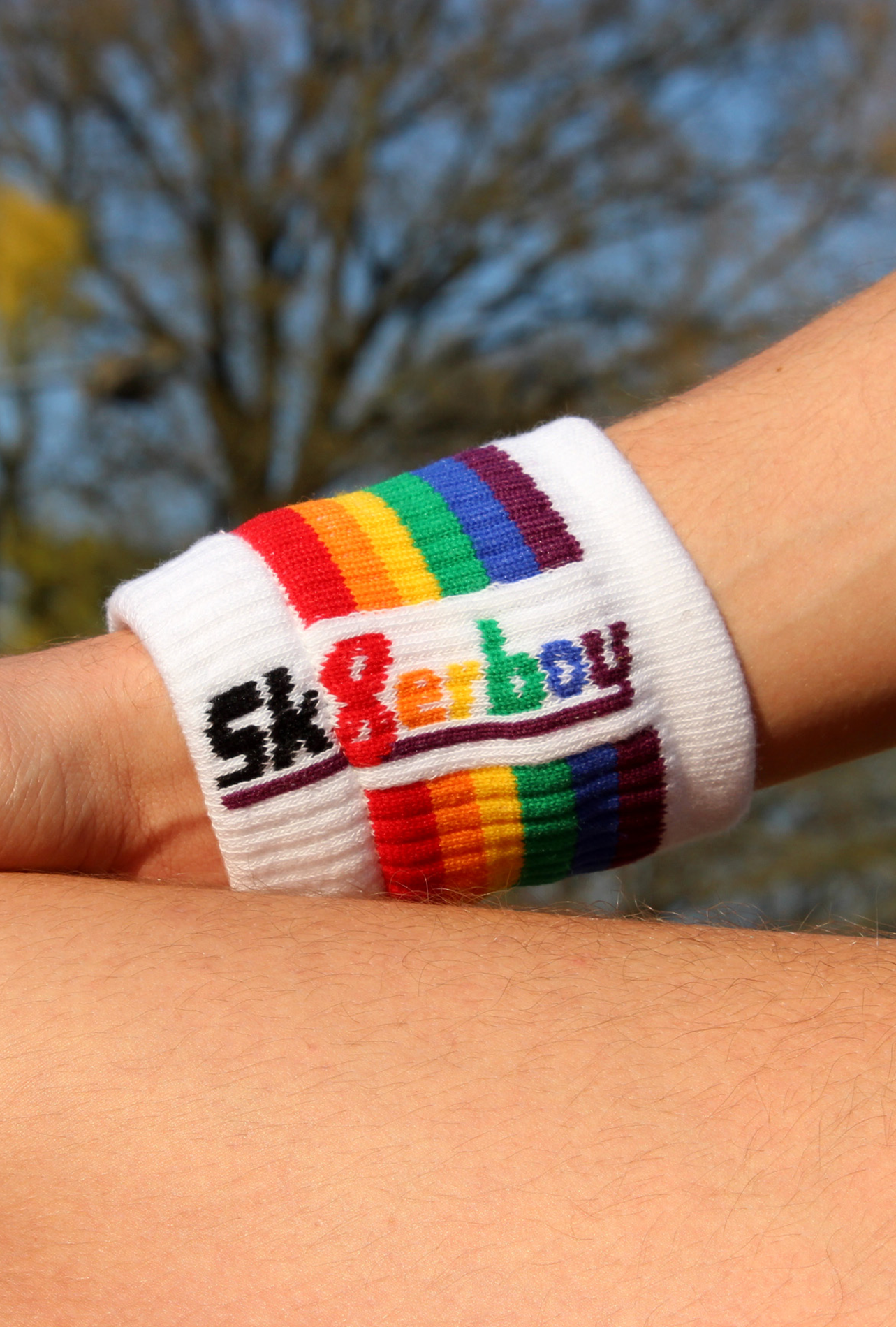 homme gay dans l’obscurité avec un boxer noir Sk8erboy et un bandeau au bras gauche avec le logo de la boutique de chaussettes Sk8erboy, fierté arc-en-ciel LGBT