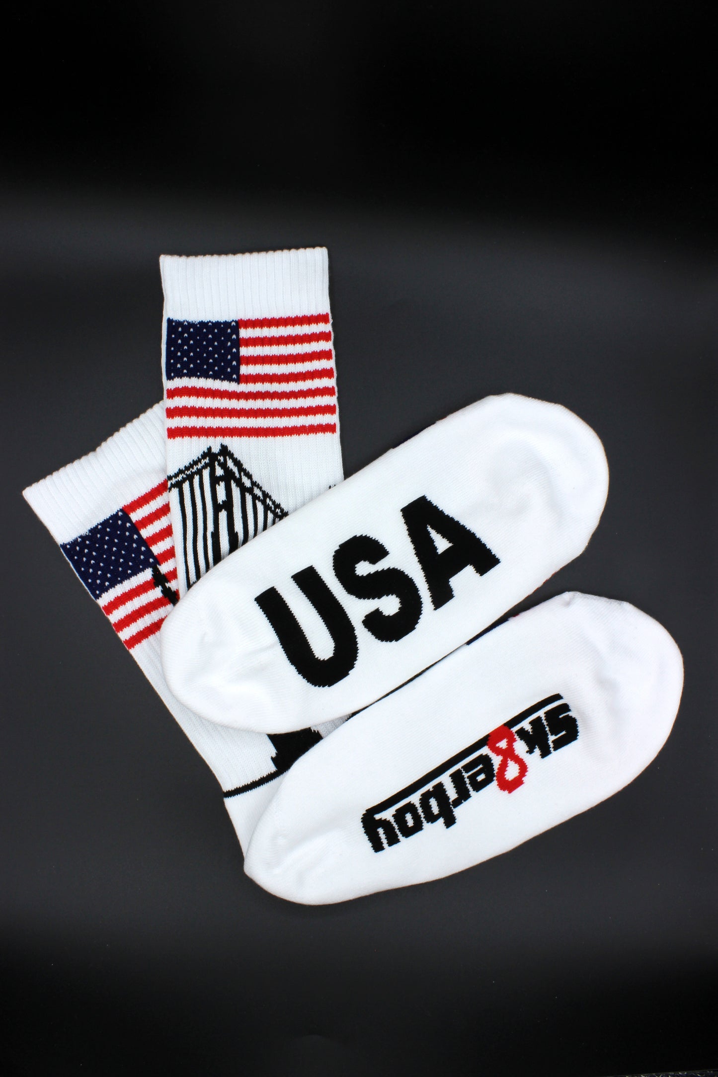 sk8erboy usa socken mit stars und stripes am bund und den zehen und großer usa aufschrift mit sk8erboy logo auf der unterseite mit liberty und golden gate bridge am bund in detailansicht