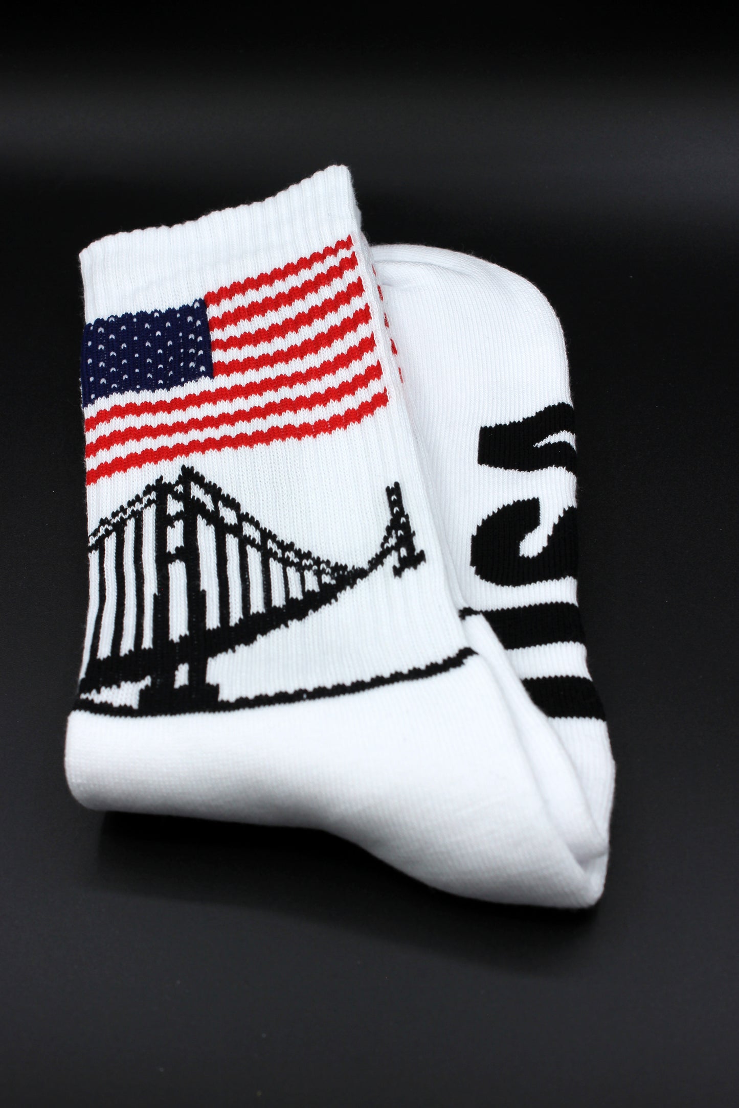 sk8erboy usa socken mit stars und stripes am bund und den zehen und großer usa aufschrift mit sk8erboy logo auf der unterseite mit liberty und golden gate bridge am bund in detailansicht