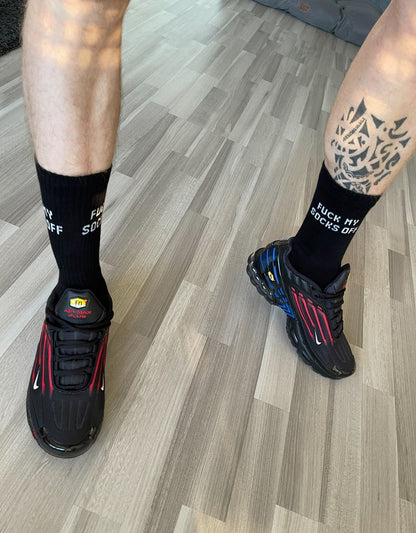 sportliche beine mit tattoo und schwarzen sk8erboy sniff me socken tragen coole nike tn in schwarz mit blauen und roten streifen