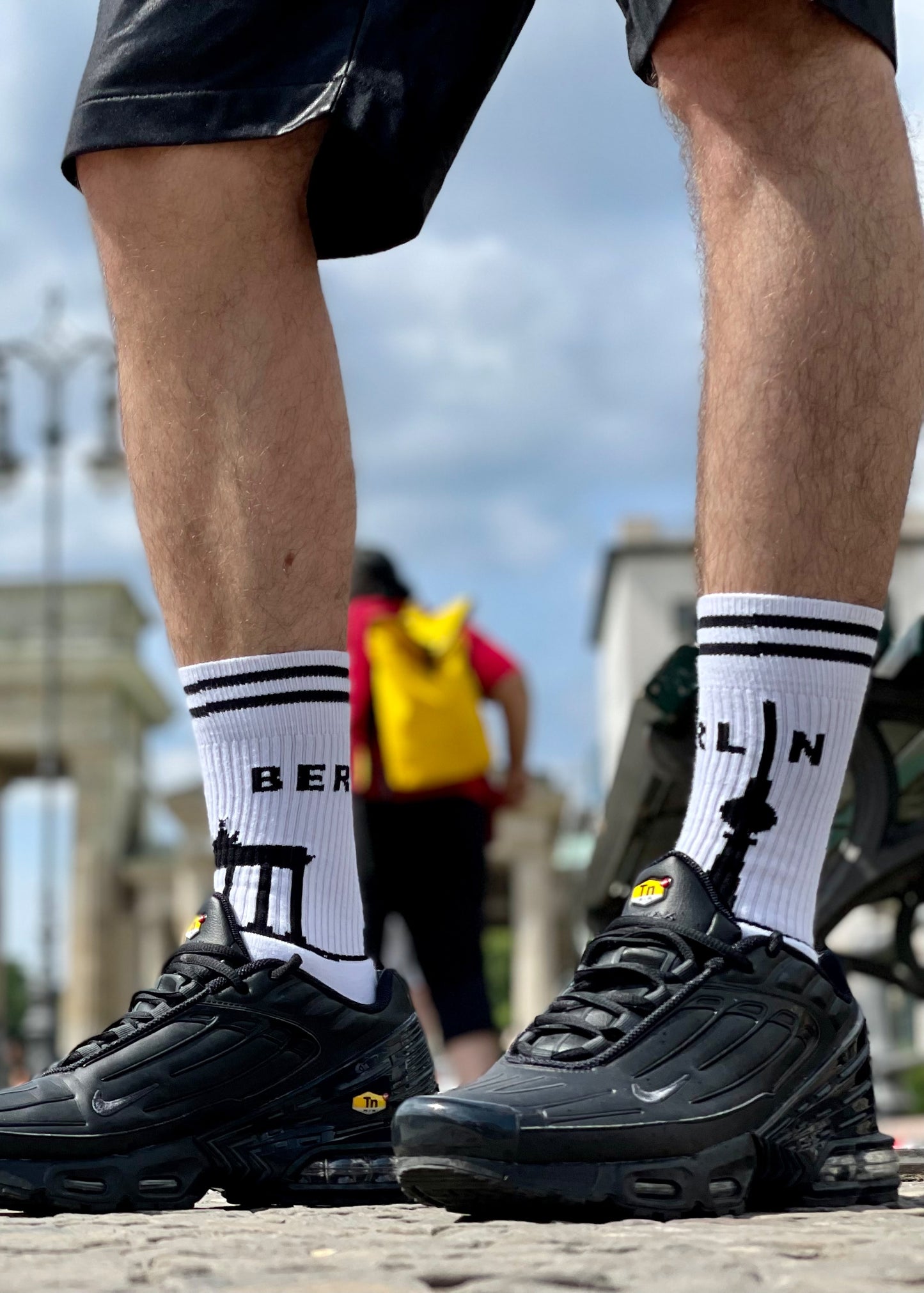 junger gay in berlin mit sk8erboy berlin socken und nike tn sneaker in kurzer short vor dem brandenbuger tor