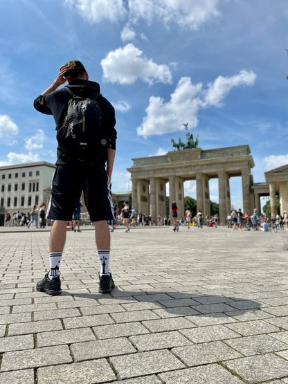 junger gay in berlin mit sk8erboy berlin socken und nike tn sneaker in kurzer short vor dem brandenbuger tor