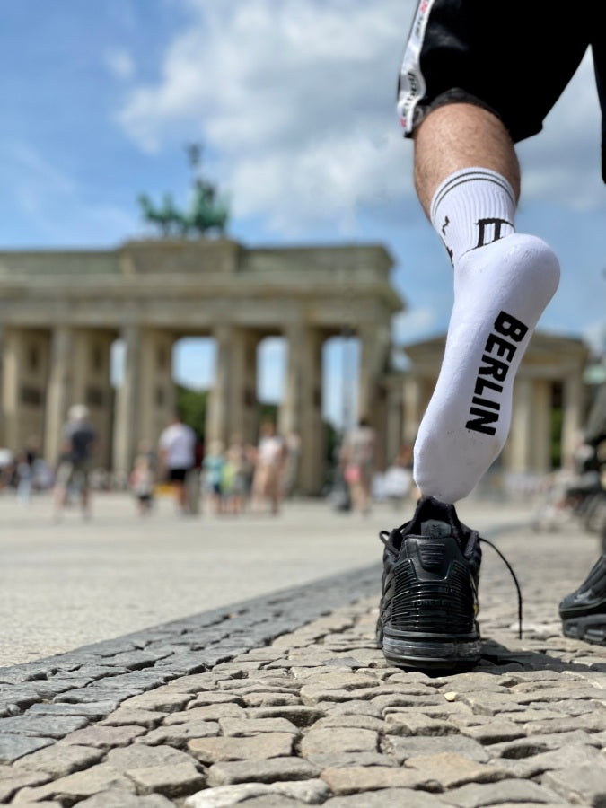 junger gay in berlin mit sk8erboy berlin socken und nike tn sneaker in kurzer short vor dem brandenbuger tor