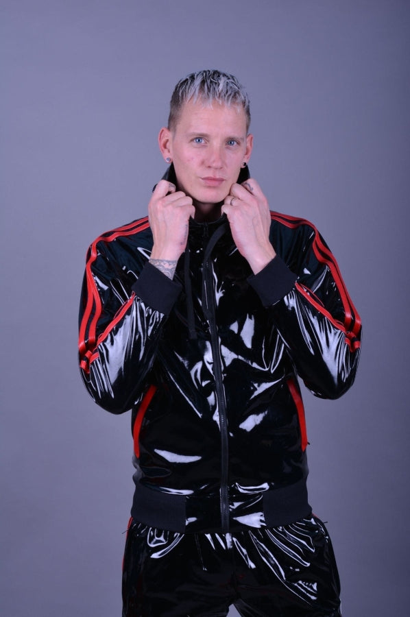 junger gay trägt einen glänzenden fetisch pvc trainingsanzug von mr riegillio in schwarz mit roten streifen