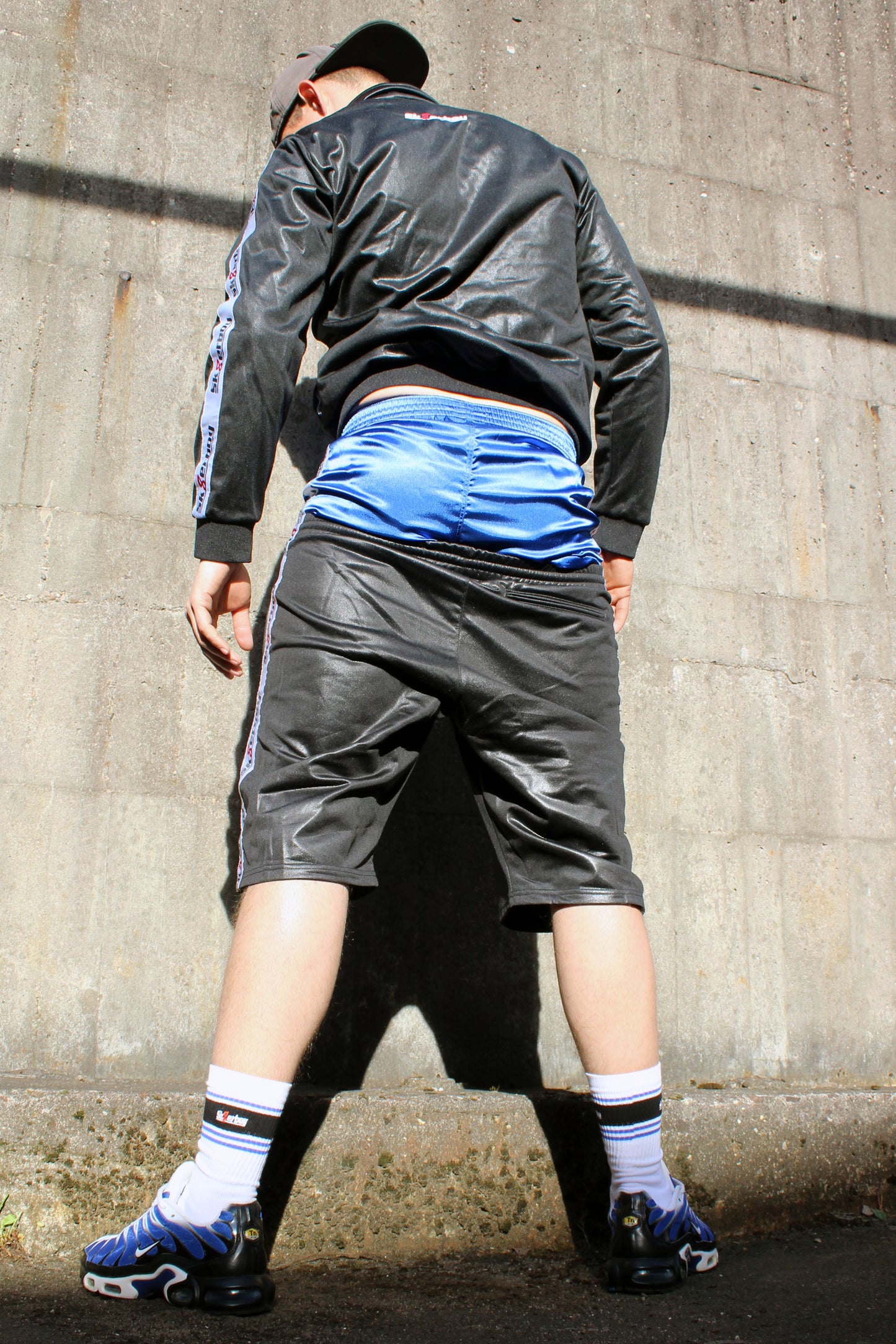 sk8erboy shiny Glanz glaenzende boxershort in royalblau blue mit fettem sk8erboy satin streifen an der Seite der boy Kerl Bengel toy traegt noch das komplette shiny sk8erboy outfit mit Jacke und short seine drolligen deluxe socks auch in royalblau smellen fett aus den nike tn tuned air max plus raus in einem stylischen Sammlerfarbton er kniet auf beton