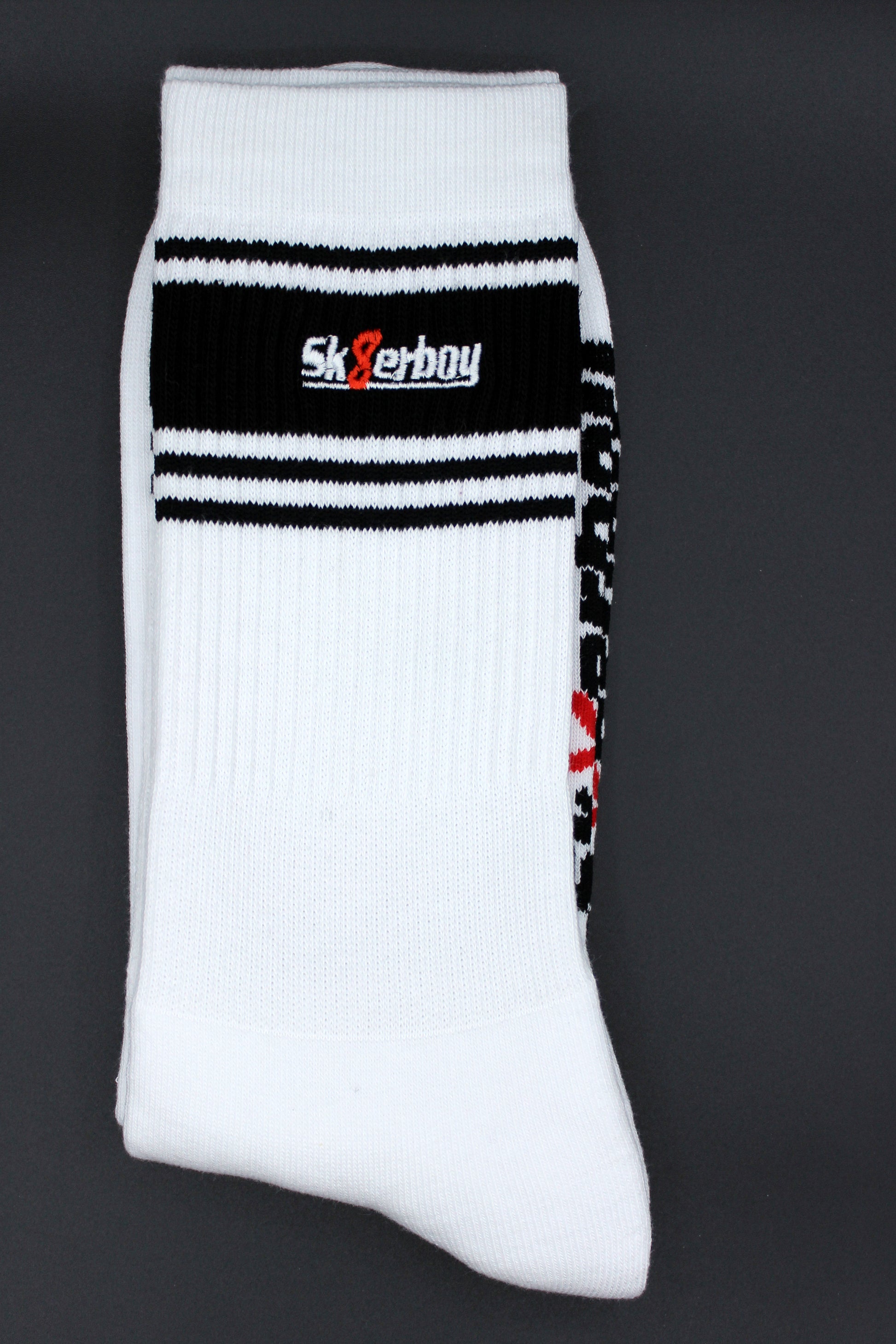 detailansicht der sk8erboy deluxe socken in schwarz mit schwarzem streifen am bund und sk8erboy logo auf der extra flauschigen unterseite