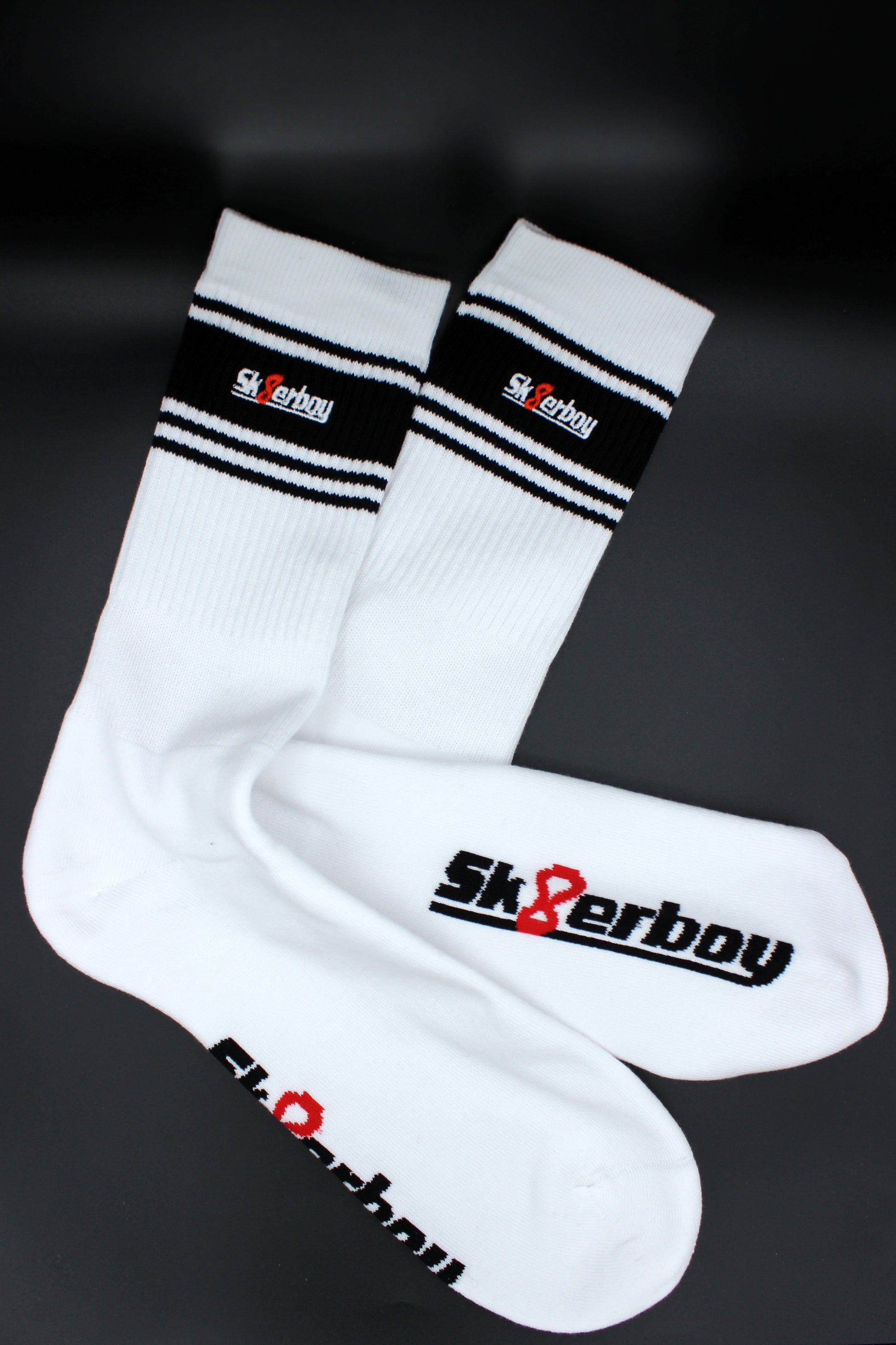 detailansicht der sk8erboy deluxe socken in schwarz mit schwarzem streifen am bund und sk8erboy logo auf der extra flauschigen unterseite