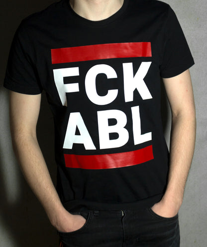 junge vor einer wand mit einem schwarzen t-shirt und dem aufdruck fck abl in weiss und zwei roten blaken