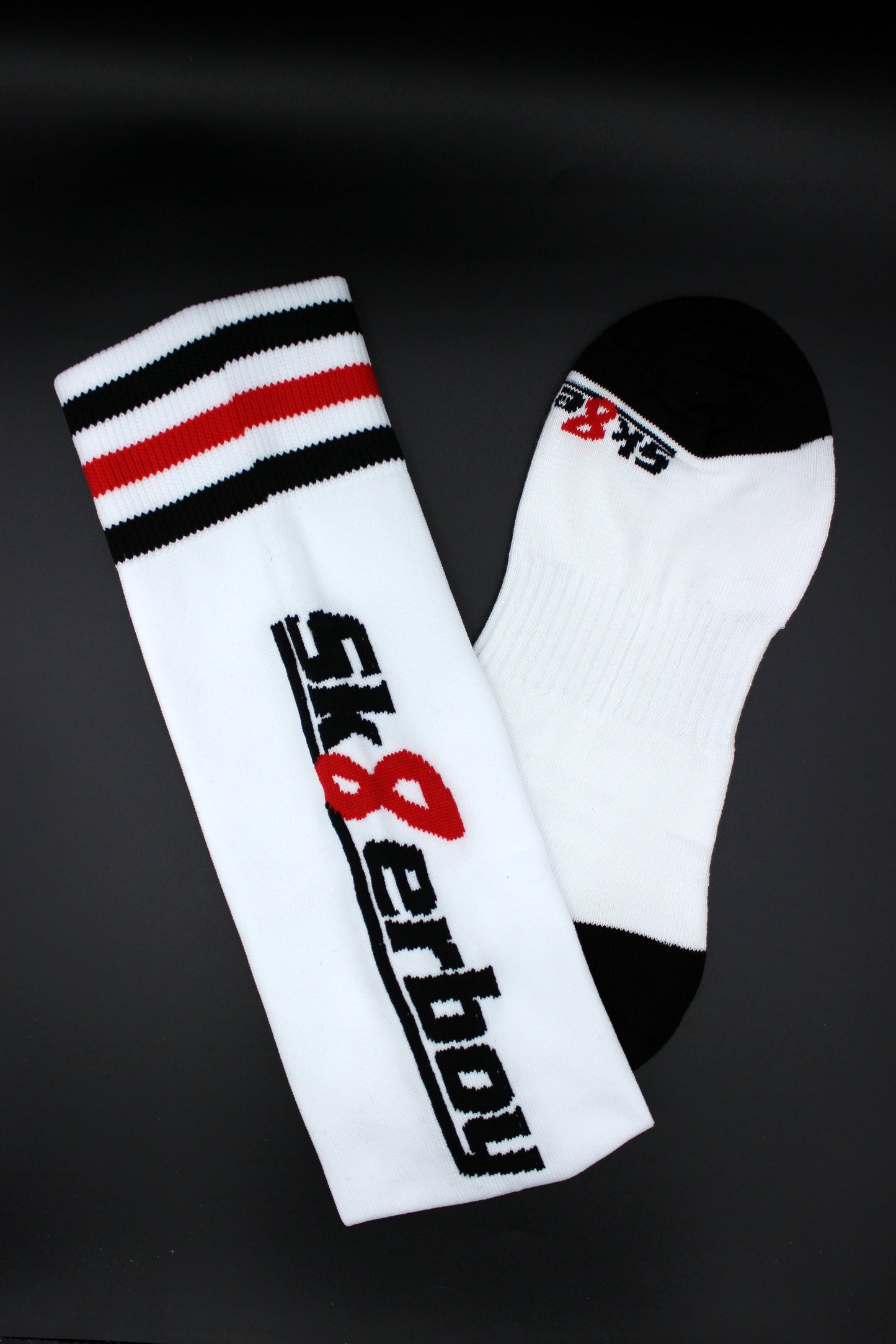 detailaufnahme der sk8erboy soccer stutzen mit großem logo auf der wade und schwarz weiss rotem bund