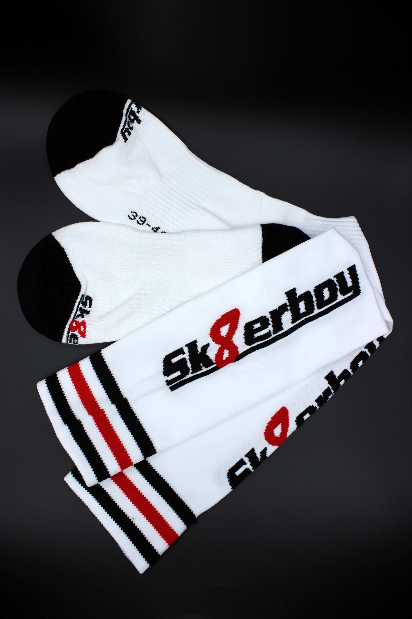 detailaufnahme der sk8erboy soccer stutzen mit großem logo auf der wade und schwarz weiss rotem bund