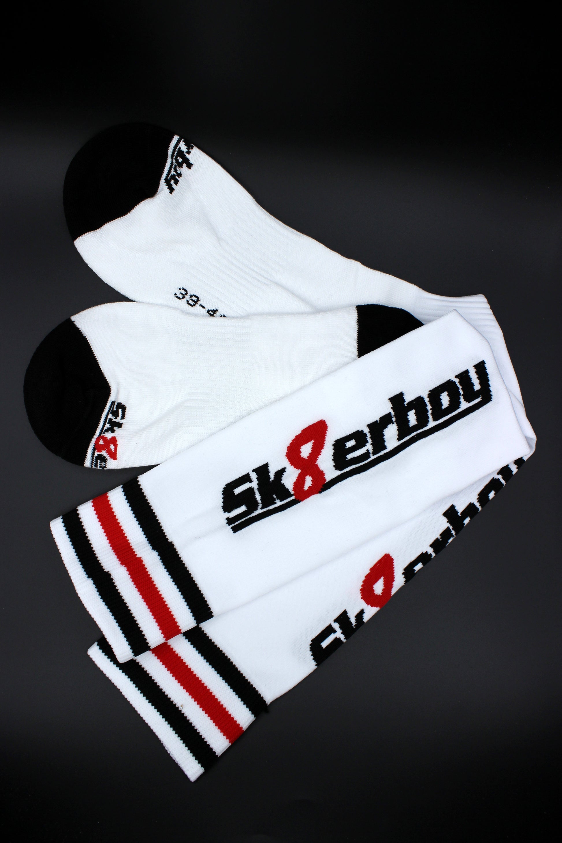 detailaufnahme der sk8erboy soccer stutzen mit großem logo auf der wade und schwarz weiss rotem bund
