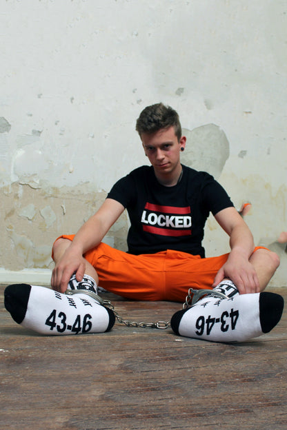 junger gay traegt locked socks von sk8erboy mit schloss am bund und 365 24 7 am bund fuer fans von chastity und keuschheit oder bondage mit locked t-shirt von sk8erboy und fesseln am bein