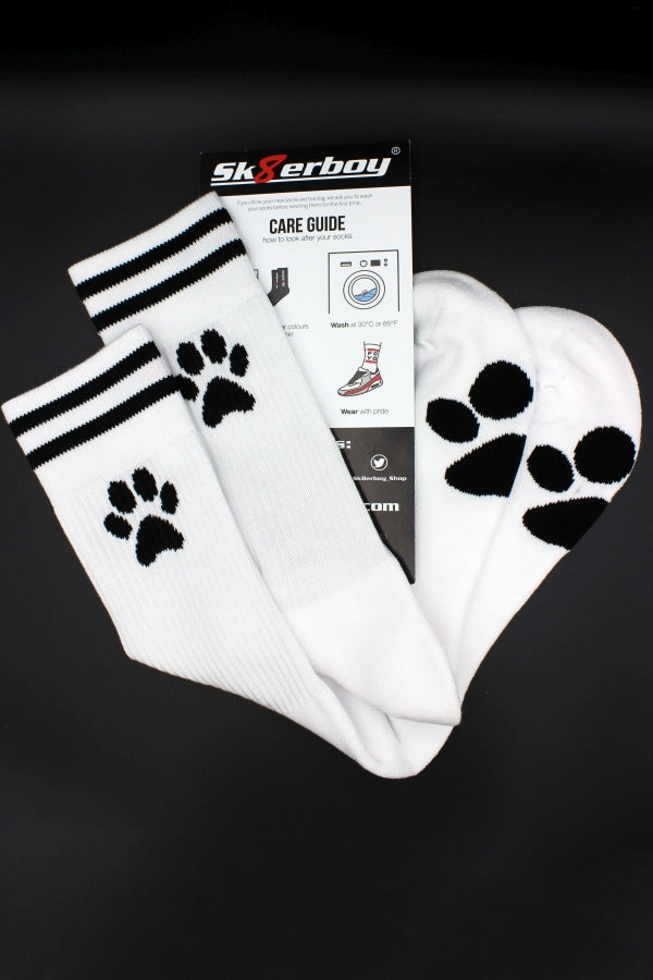 sk8erboy puppy socks socken mit pfote auf der sohle in weiss fuer alle doggys und puppys und verstecktem sk8erboy logo auf der innenseite im bund mit waschanleitung und verpackung zu sehen