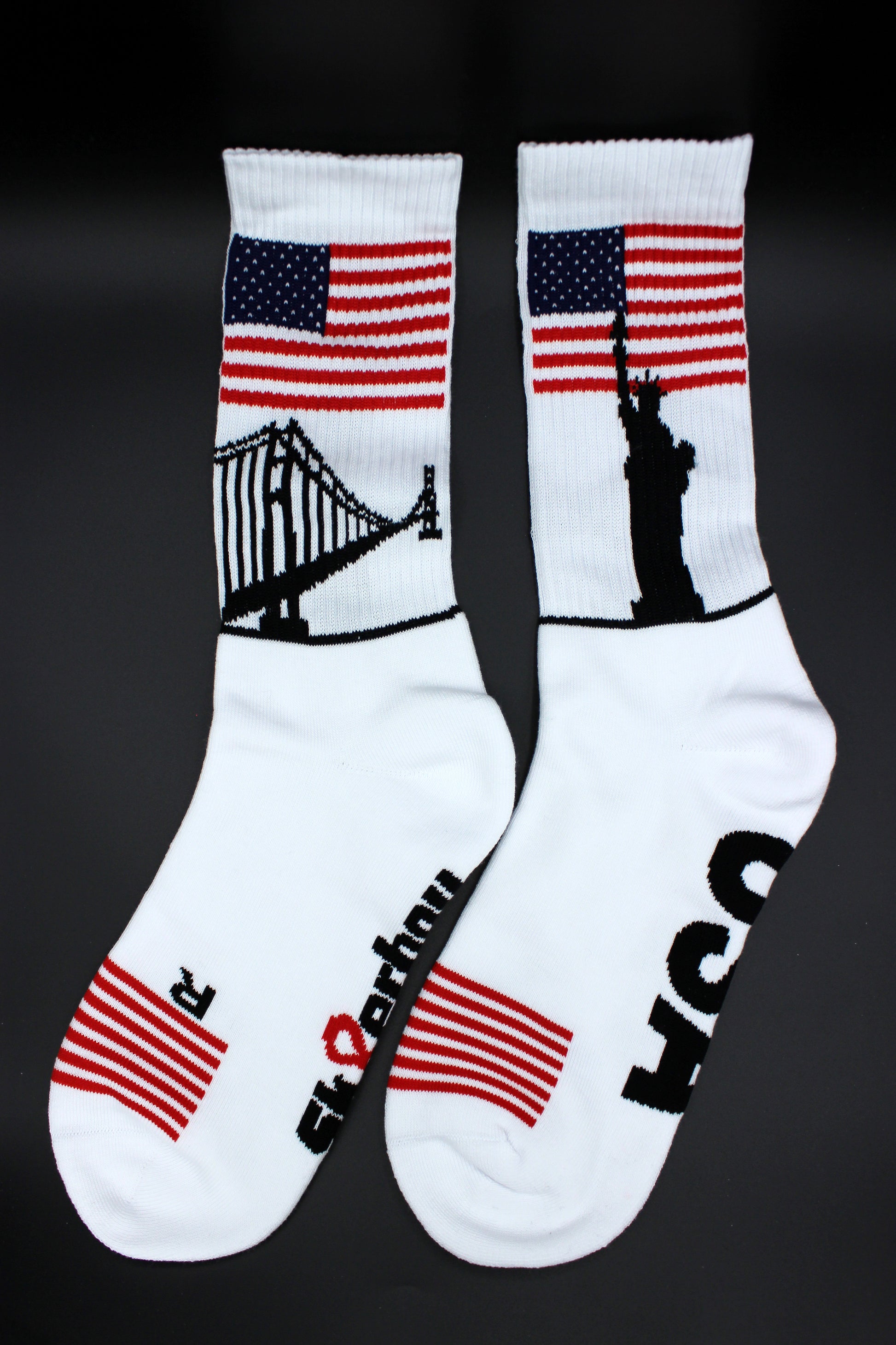 sk8erboy usa socken mit stars und stripes am bund und den zehen und großer usa aufschrift mit sk8erboy logo auf der unterseite mit liberty und golden gate bridge am bund in detailansicht