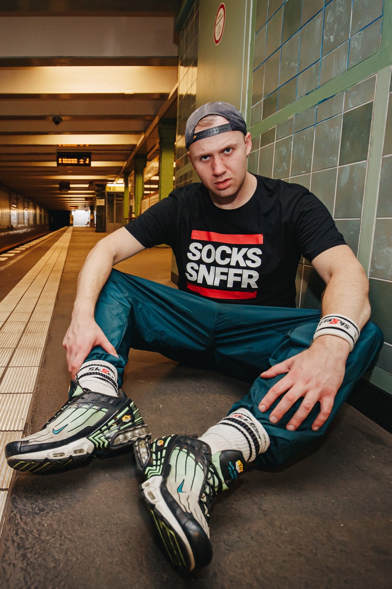 sk8erboy victory socken extra dünn in bekannter qualität jedoch besonders leicht und ideal für den sommer in weiss mit nike tn sneakern werden von einem jungen der am boden eines u-bahnhofes sitzt getragen